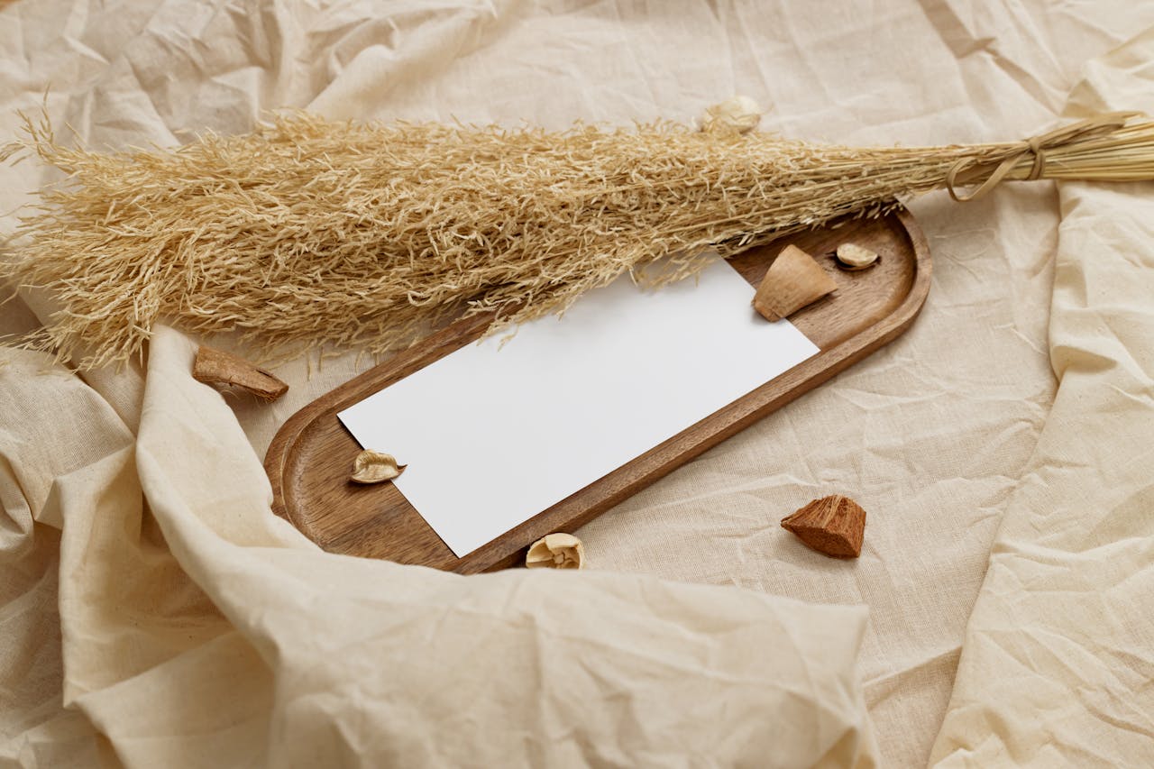 Close-up of a wooden tray with dried grass on a neutral fabric background, perfect for natural decor themes.