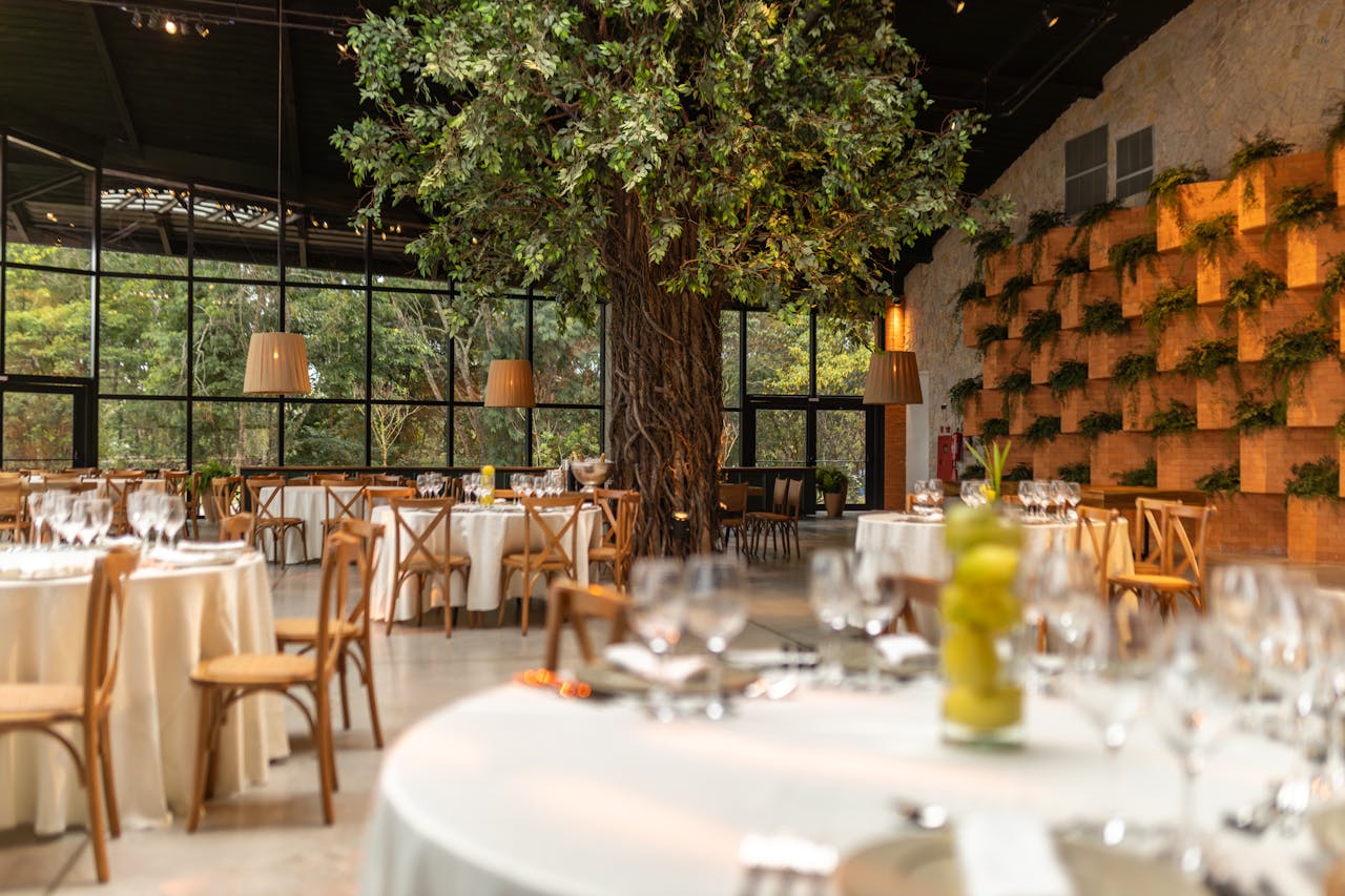 Luxurious restaurant space featuring a central decorative tree and large glass walls for a modern, serene ambiance.