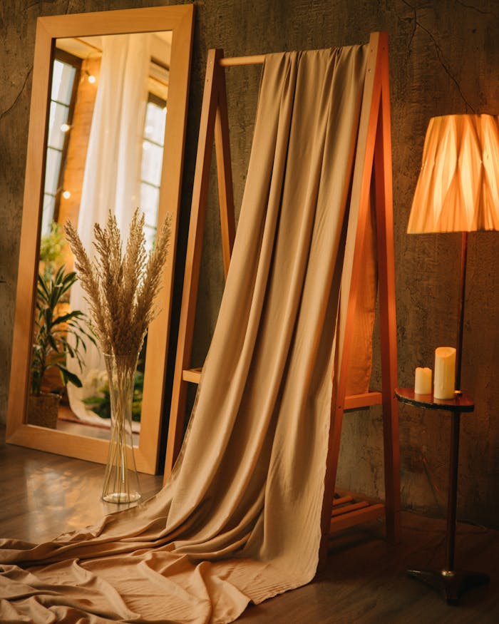 Warm interior design with elegant drapery, mirror, and soft lighting creates a cozy atmosphere.